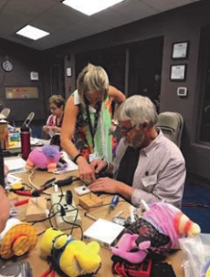 A group of people at a pediatric therapy center working on a table with stuffed animals.