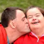 A couple sharing an affectionate kiss on a bench in a community park. A couple sharing an affectionate kiss on a bench in a community park.