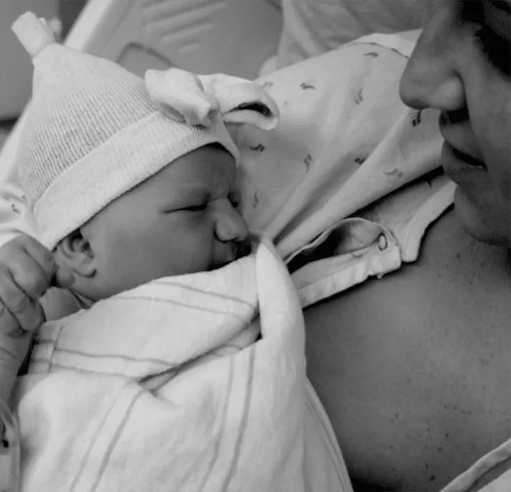 A woman is holding a baby in a hospital bed, possibly receiving day treatment for adults or pediatric therapy. A woman is holding a baby in a hospital bed, possibly receiving day treatment for adults or pediatric therapy.