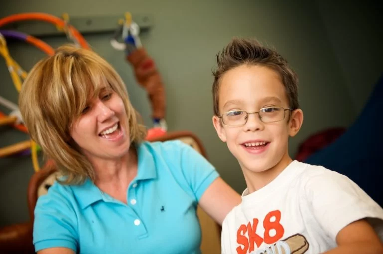 A woman and a young boy engaging in pediatric therapy with toys at Cerebral Palsy of Arizona. A woman and a young boy engaging in pediatric therapy with toys at Cerebral Palsy of Arizona.