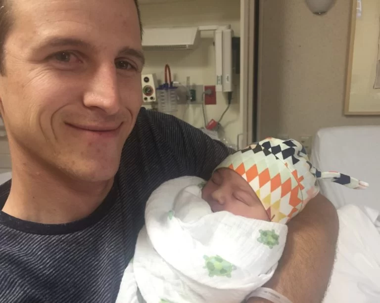 A man holding a baby in a pediatric therapy session. A man holding a baby in a pediatric therapy session.