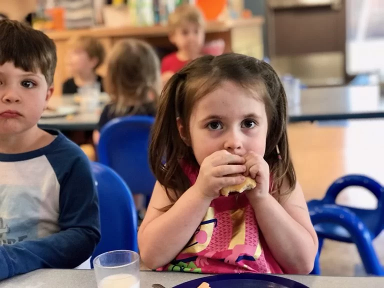 Two children with cerebral palsy of Arizona eating at a table in an early learning center. Two children with cerebral palsy of Arizona eating at a table in an early learning center.