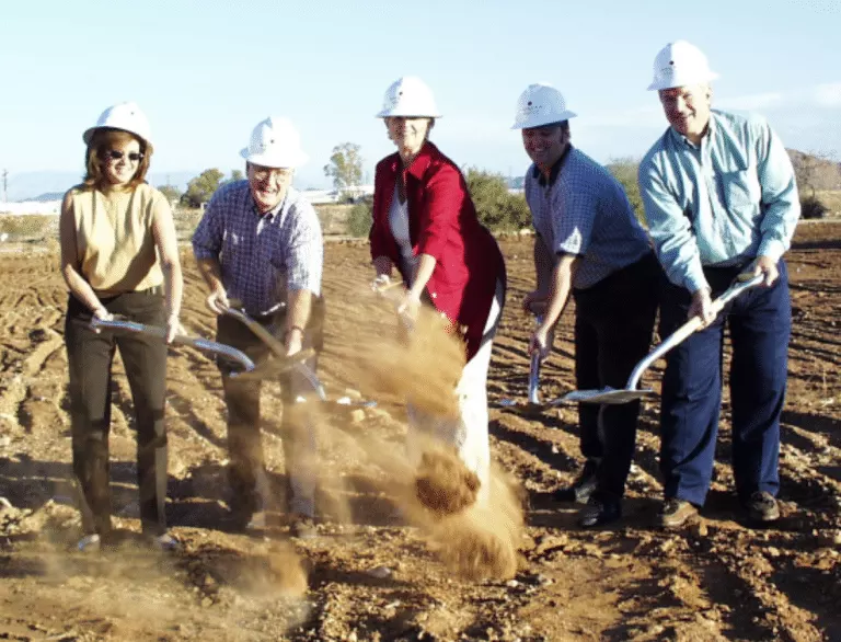 A group of adults from the Cerebral Palsy of Arizona engaging in day treatment, holding shovels in a dirt field at an early learning center. A group of adults from the Cerebral Palsy of Arizona engaging in day treatment, holding shovels in a dirt field at an early learning center.