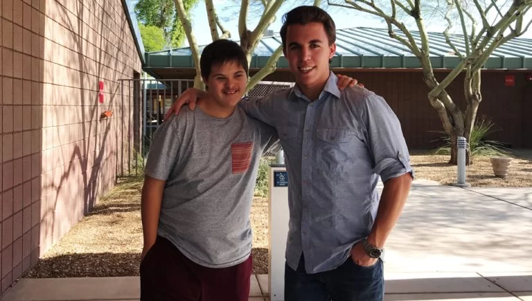 Two boys with cerebral palsy of Arizona posing for a picture in front of a building. Two boys with cerebral palsy of Arizona posing for a picture in front of a building.