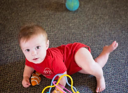 A baby engaging with toys in an early learning center. A baby engaging with toys in an early learning center.