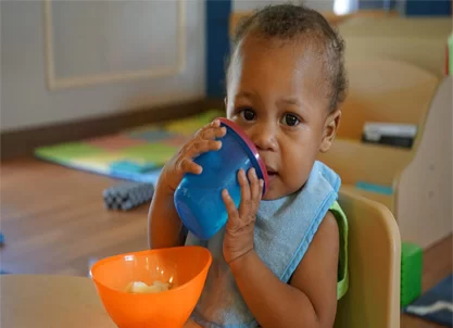 A baby with cerebral palsy of Arizona drinking from a bowl in an early learning center. A baby with cerebral palsy of Arizona drinking from a bowl in an early learning center.