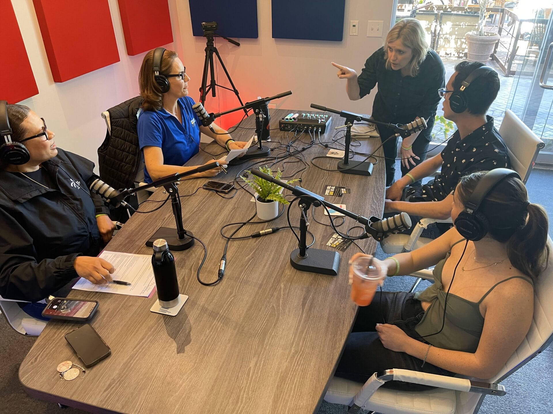 ucp of central az ambassadors and vp Camille Ridley recording a podcast around a table with microphones,