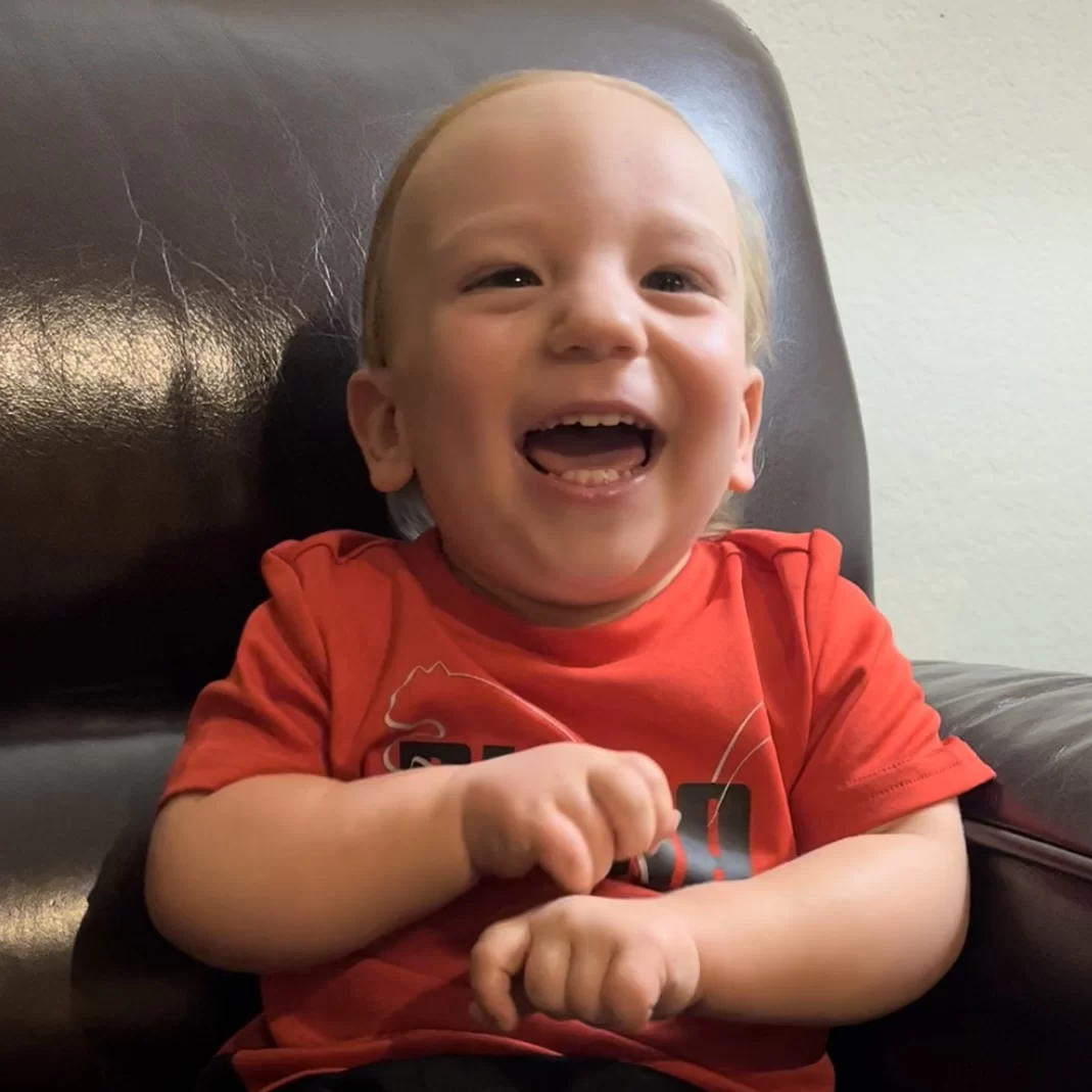 A baby with cerebral palsy of Arizona is sitting in a chair at an early learning center and laughing. A baby with cerebral palsy of Arizona is sitting in a chair at an early learning center and laughing.
