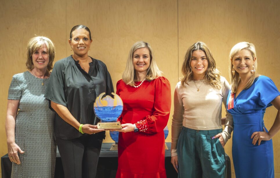 Mayor Kate Gallego posing with the 2023 D.A.R.E. Nonprofit Year Award in front of a table.