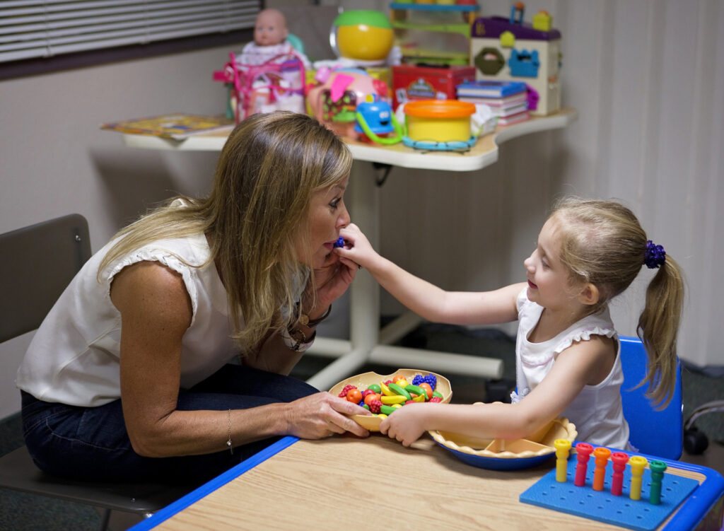 A little girl with cerebral palsy being fed by a woman at the Early Learning Center in Arizona. A little girl with cerebral palsy being fed by a woman at the Early Learning Center in Arizona.