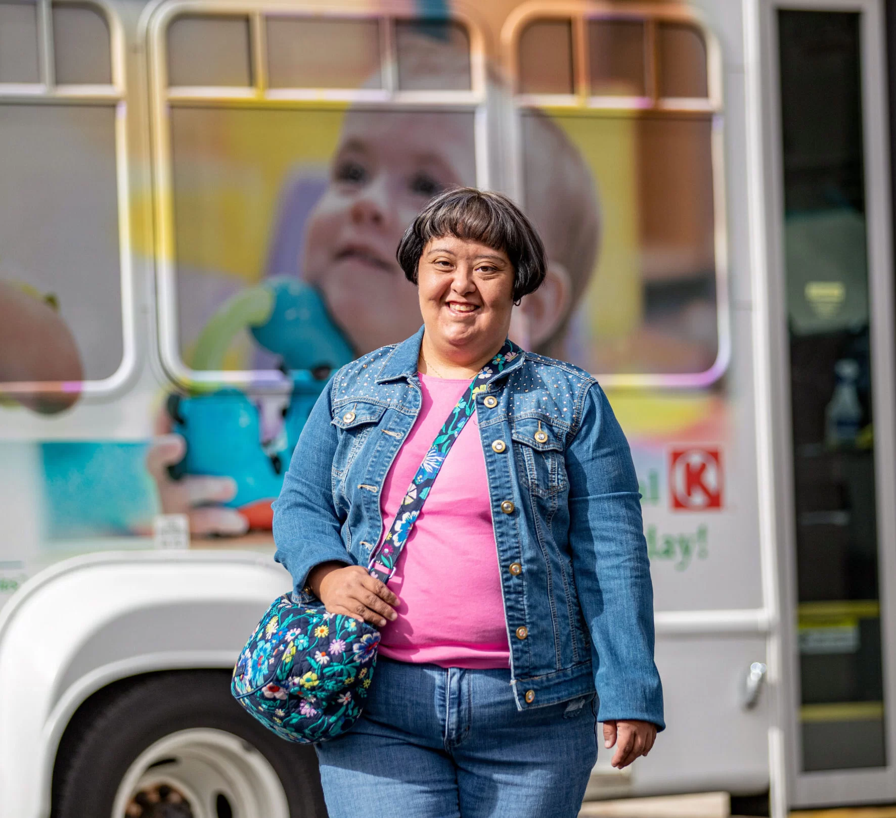 A woman with cerebral palsy standing in front of a bus, potentially accessing home and community based services or pediatric therapy. A woman with cerebral palsy standing in front of a bus, potentially accessing home and community based services or pediatric therapy.
