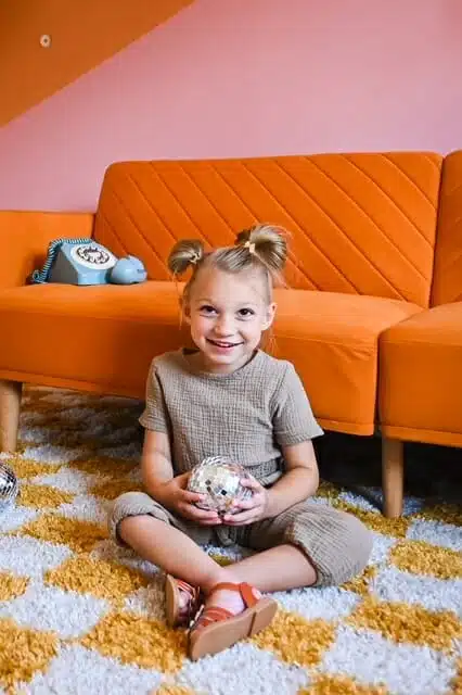 Nora sitting infront of her couch UCP family ambassador, Nora.